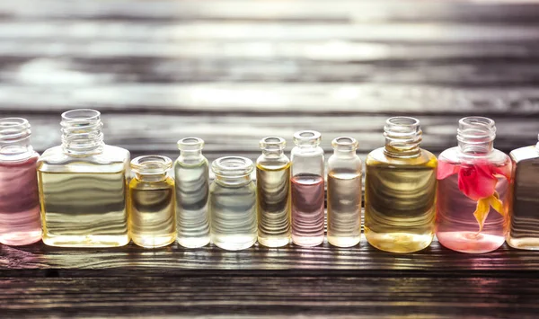 Lahvičky parfému na dřevěném stole — Stock fotografie