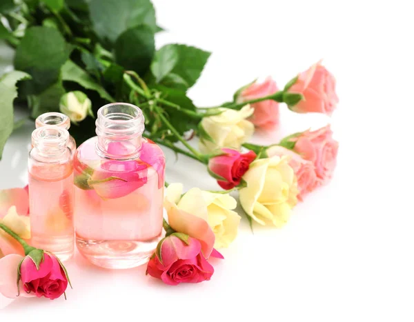 Parfymflaskor och rosor — Stockfoto