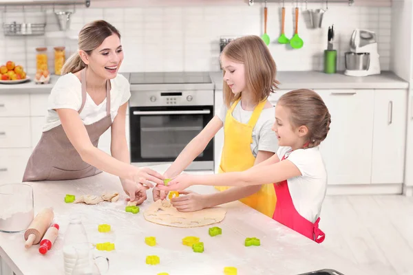 Женщина и дочери готовят на кухне — стоковое фото