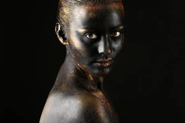 Женщина с темной краской и блестками на теле — стоковое фото