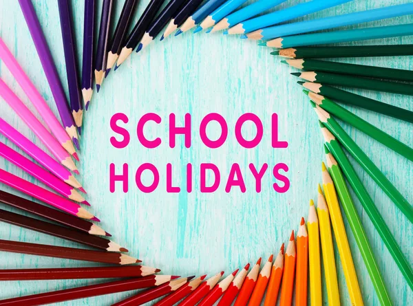 Текст SCHOOL HOLIDAYS і барвисті олівці — стокове фото