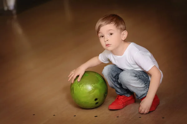 Bambino carino con palla nel bowling club — Foto Stock