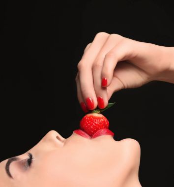 Çilek yiyen genç bir kadın