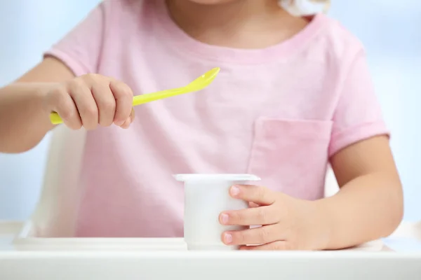 Liten flicka äter yoghurt — Stockfoto