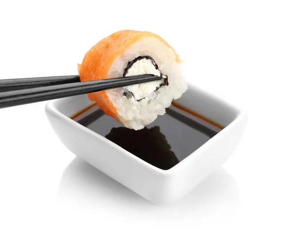 Dipping roll into bowl with soy sauce — Stock Photo, Image