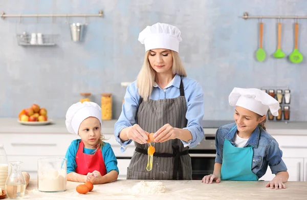 Mulher e filhas cozinhar na cozinha — Fotografia de Stock