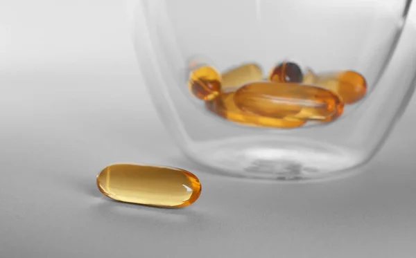 Glas met vis olie capsules — Stockfoto