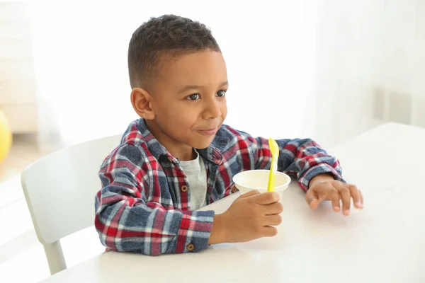 Афроамериканський хлопчик їсть йогурт — стокове фото