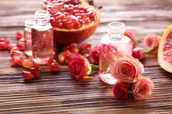 Flacons de parfum, roses et grenade — Photo