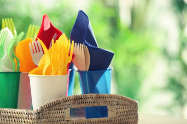 Plastic ware in wicker tray