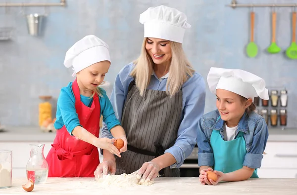 Mulher e filhas cozinhar na cozinha — Fotografia de Stock