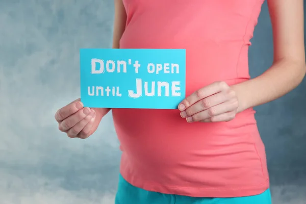 Femme enceinte tenant du papier avec des mots N'OUVERT PAS JUNE — Photo