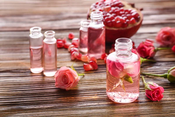 Perfume bottles, roses and pomegranate — Stock Photo, Image