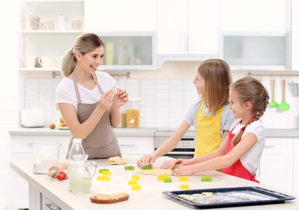 Mulher e filhas cozinhar na cozinha — Fotografia de Stock