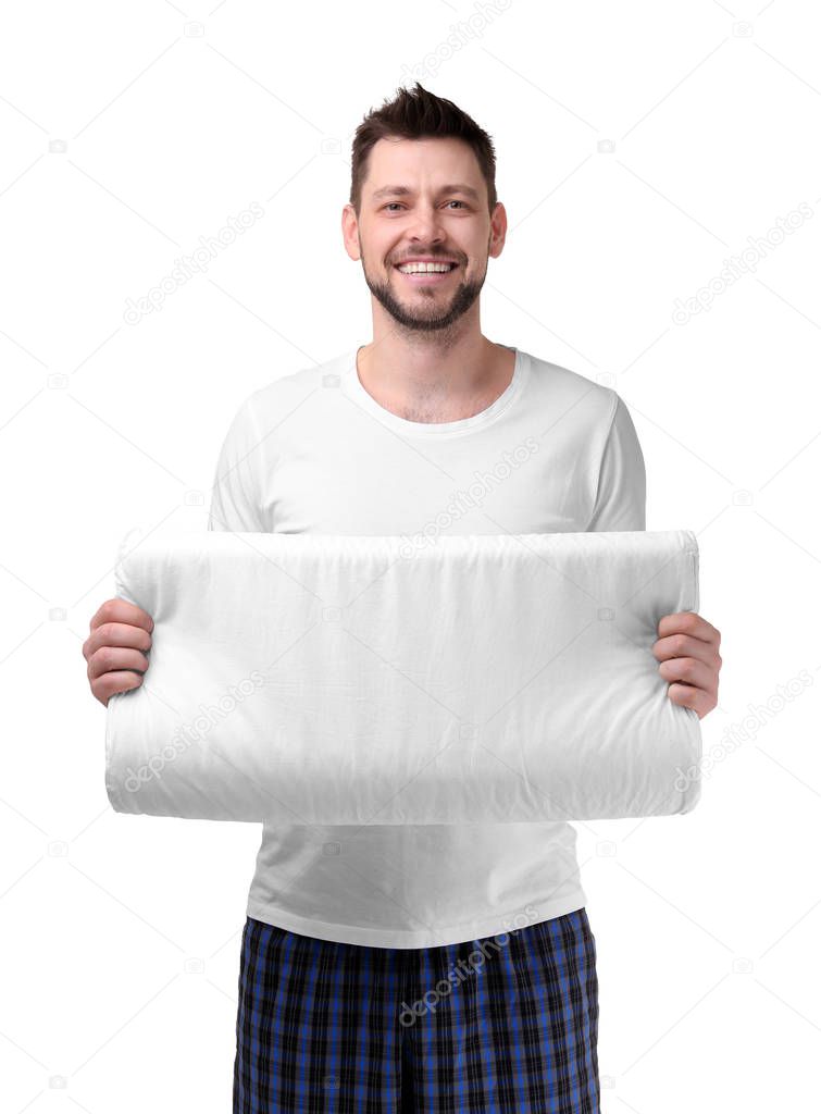 Young man in pajamas holding pillow
