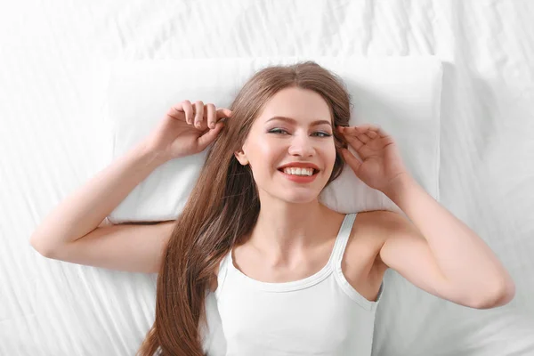 Mujer acostada en la cama con almohada ortopédica —  Fotos de Stock