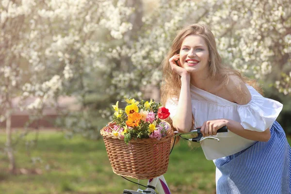 Chica de pie cerca de bicicleta en el parque — Foto de Stock