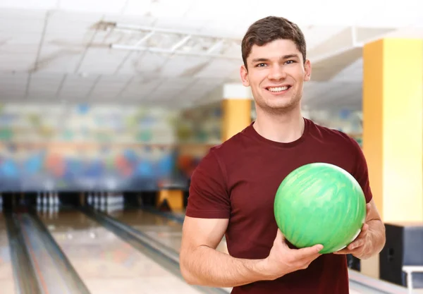 Jovem bonito com bola no clube de boliche — Fotografia de Stock