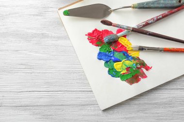 Yağlı boya, fırça ve palet bıçağı masada kağıt