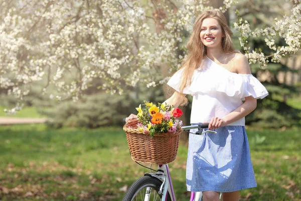 Flicka som står nära cykel i park — Stockfoto