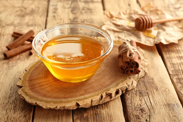 Cinnamon and honey in bowl — Stock Photo, Image