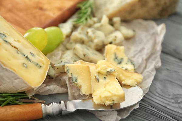 Κομμάτια τυριού με μπλε στίγματα σε περγαμηνή — Φωτογραφία Αρχείου