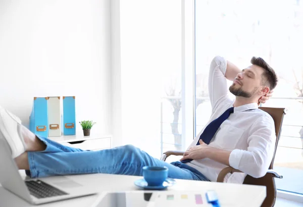 Young businessman relaxing at workplace — Stock Photo, Image