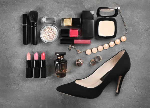 Composition of cosmetics, perfume, accessories and shoe on grey table — Stock Photo, Image