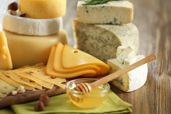 Деревянная доска с разнообразным сыром — стоковое фото