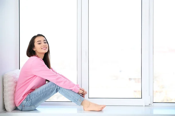 Vrouw rustend op de vensterbank — Stockfoto