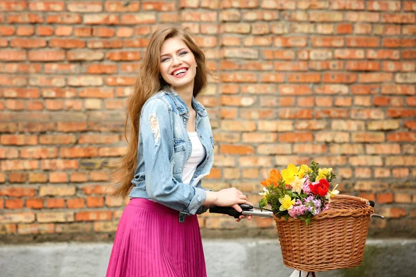 Mladá žena stojící poblíž kolo — Stock fotografie