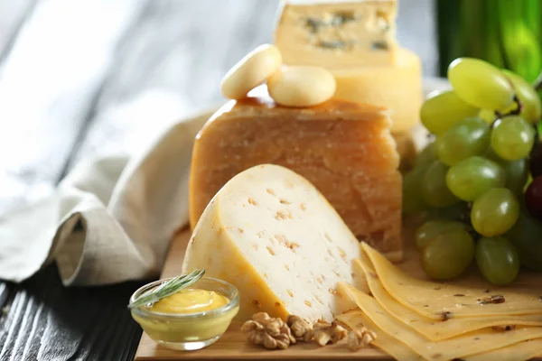 Tablero de madera con variedad de queso — Foto de Stock