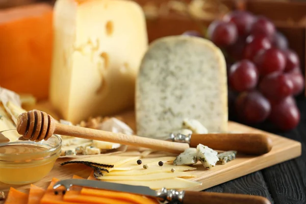 Деревянная доска с разнообразным сыром — стоковое фото