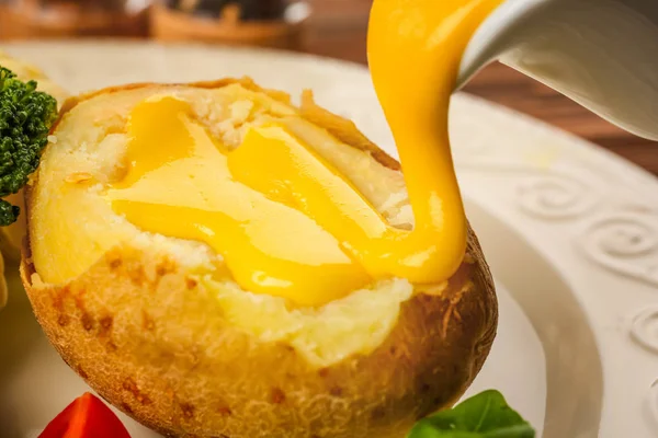 Baked potato with cheese sauce — Stock Photo, Image