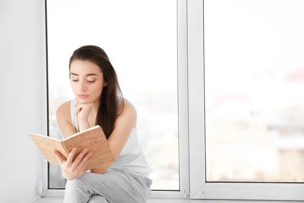 Vrouw zittend op vensterbank — Stockfoto