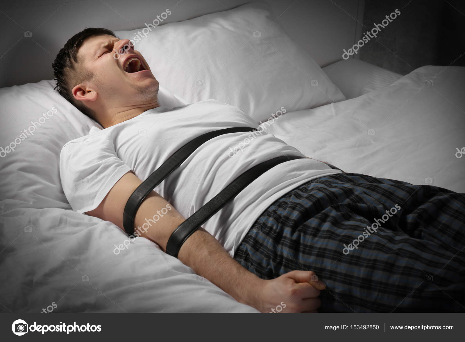 Yatakta bantlar ile bağlı genç adam — Stok Foto © belchonock #153492850