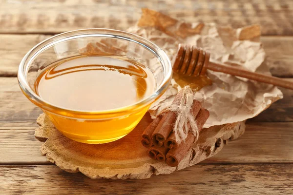 Cinnamon and honey in bowl — Stock Photo, Image