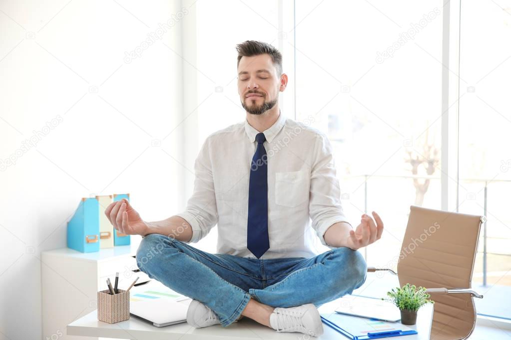 Young businessman meditating