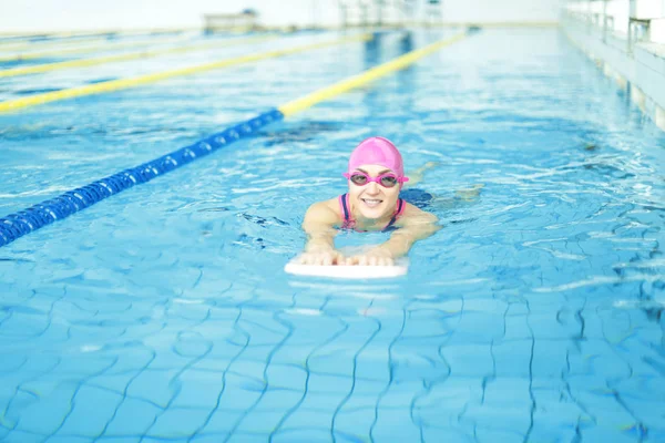 Jonge vrouw zwemmen in het zwembad — Stockfoto