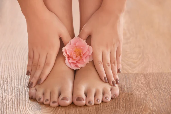 Weibliche Füße und Hände mit brauner Maniküre — Stockfoto