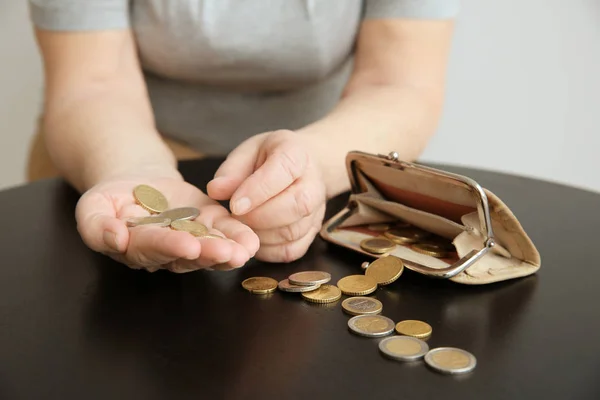 Seniorin, die Münzen zählt, während sie am Tisch sitzt, Nahaufnahme. Armutskonzept — Stockfoto