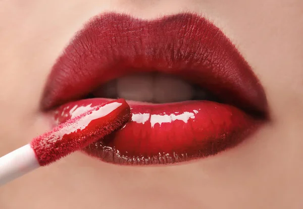 Žena použití červené lipgloss — Stock fotografie