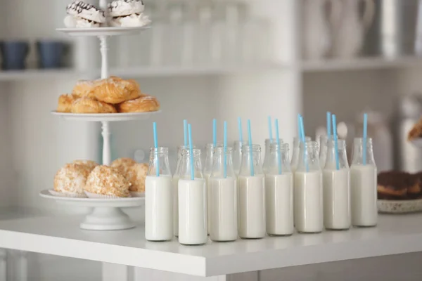 Tabell med flaskor av mjölk och dessert stand — Stockfoto