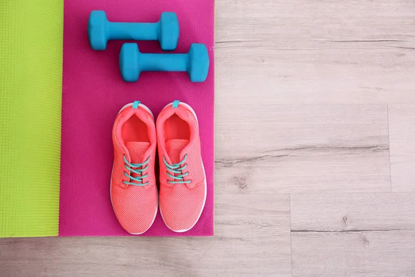 Tappetino yoga con scarpe da ginnastica e manubri — Foto Stock