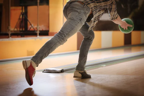 Young man throwing ball in bowling club — Stock Photo, Image