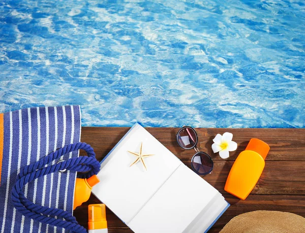 Book and cosmetic on wooden pier