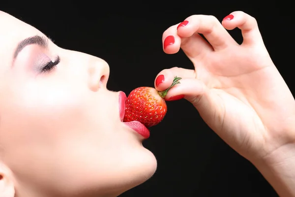Young woman eating strawberry — Stock Photo, Image