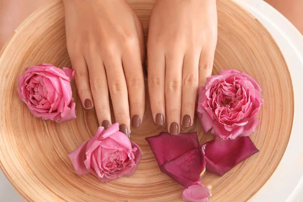 Mains féminines dans un bol en bois spa — Photo