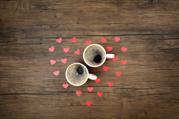 Duas xícaras de café com corações vermelhos no fundo de madeira, vista superior — Fotografia de Stock