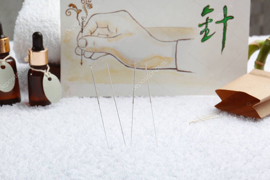 Acupuncture needles and blurred drawing on background